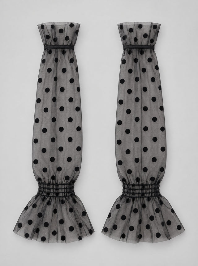 Zwarte Dotty Sleeves plat gelegd, grote dots en gesmokte pols zichtbaar