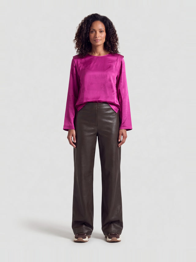 Model draagt de Mary blouse in paars satijn met bruine leren pantalon, volledig vooraanzicht