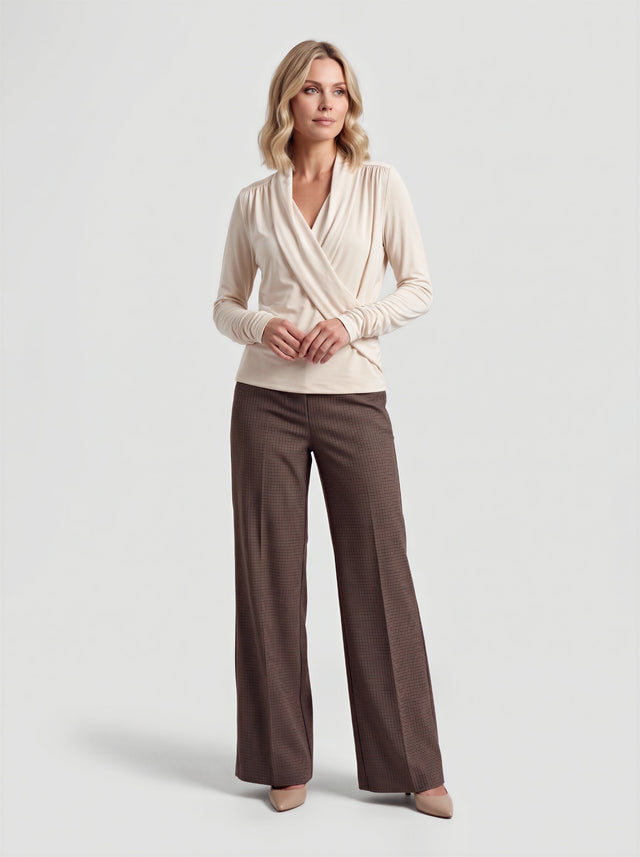 Model draagt de River top in ecru met bruine pantalon, volledig vooraanzicht
